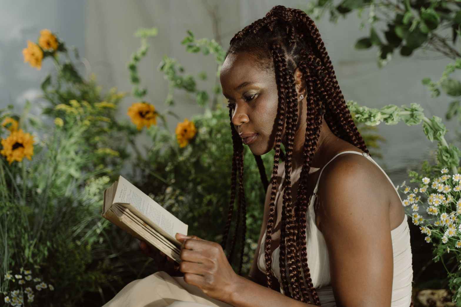 woman with braided hair reading a book